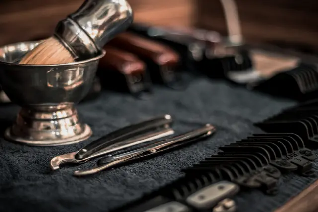 Shaving bowl, brush, razors and clipper guards on a towel