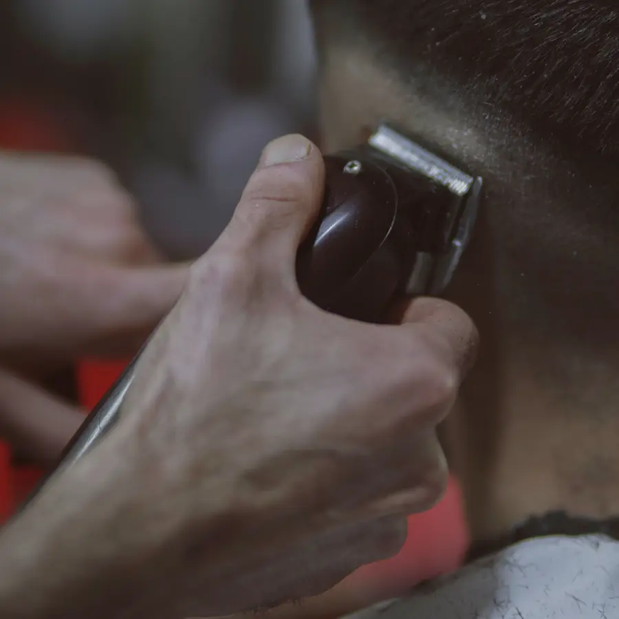 Barber shaping a neckline with clippers