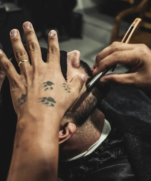 Barber shaving a client with a straight razor